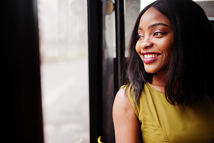Young stylish African American woman riding on a bus.